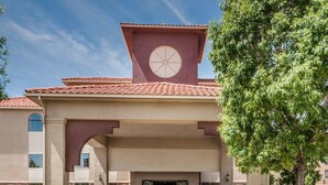 A building with a clock tower, a covered entrance, and a landscaped front yard. - Quality Inn & Suites Albuquerque West (Albuquerque)