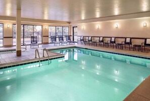 A swimming pool with chairs and sun loungers, large windows, and a tiled floor. - Hampton Inn Boulder - Louisville (Louisville)