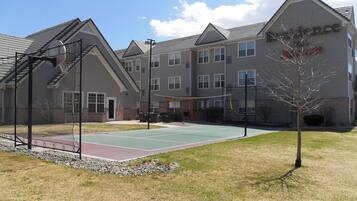 Un edificio con cancha de baloncesto y cancha de tenis.