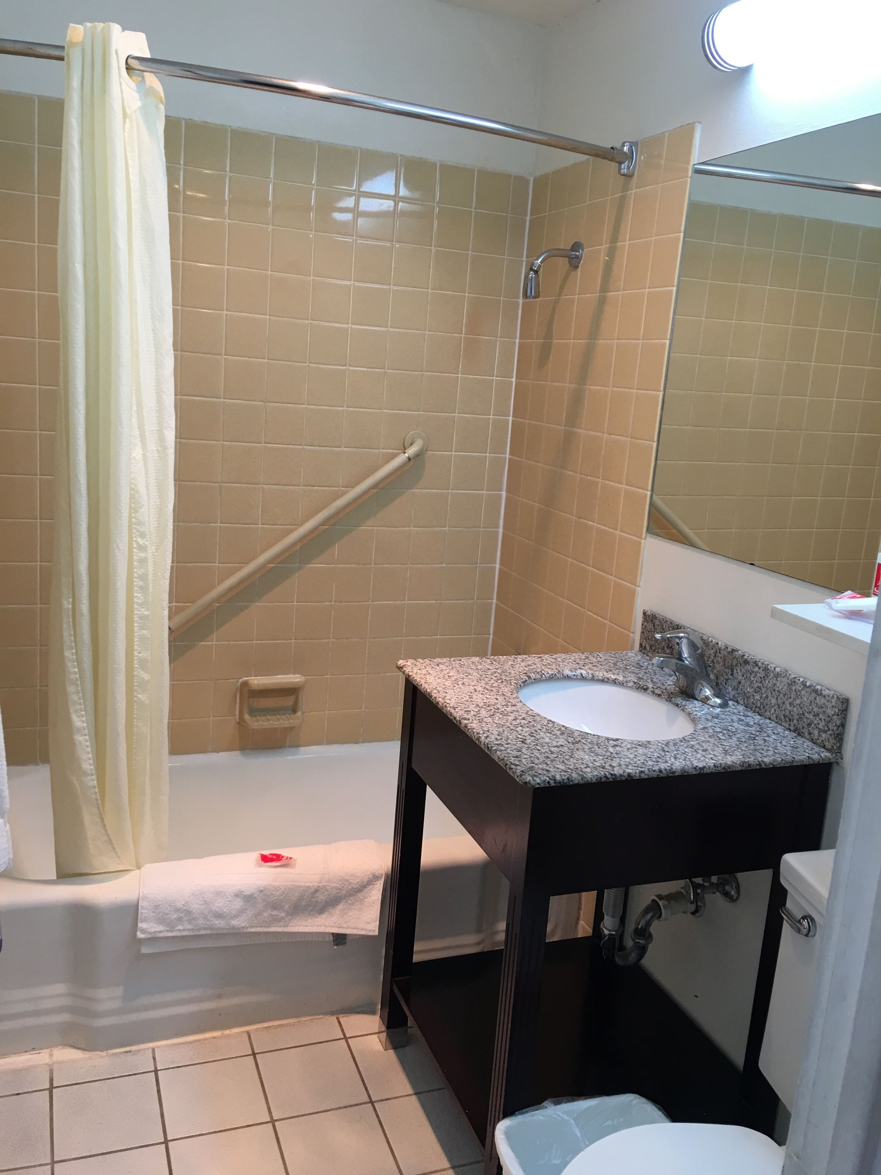 A bathroom with a shower, a sink, and a toilet.