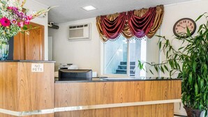 A reception desk with a 'NO PETS' sign, a clock, and a plant. - Econo Lodge Colorado Springs Downtown (Colorado Springs)