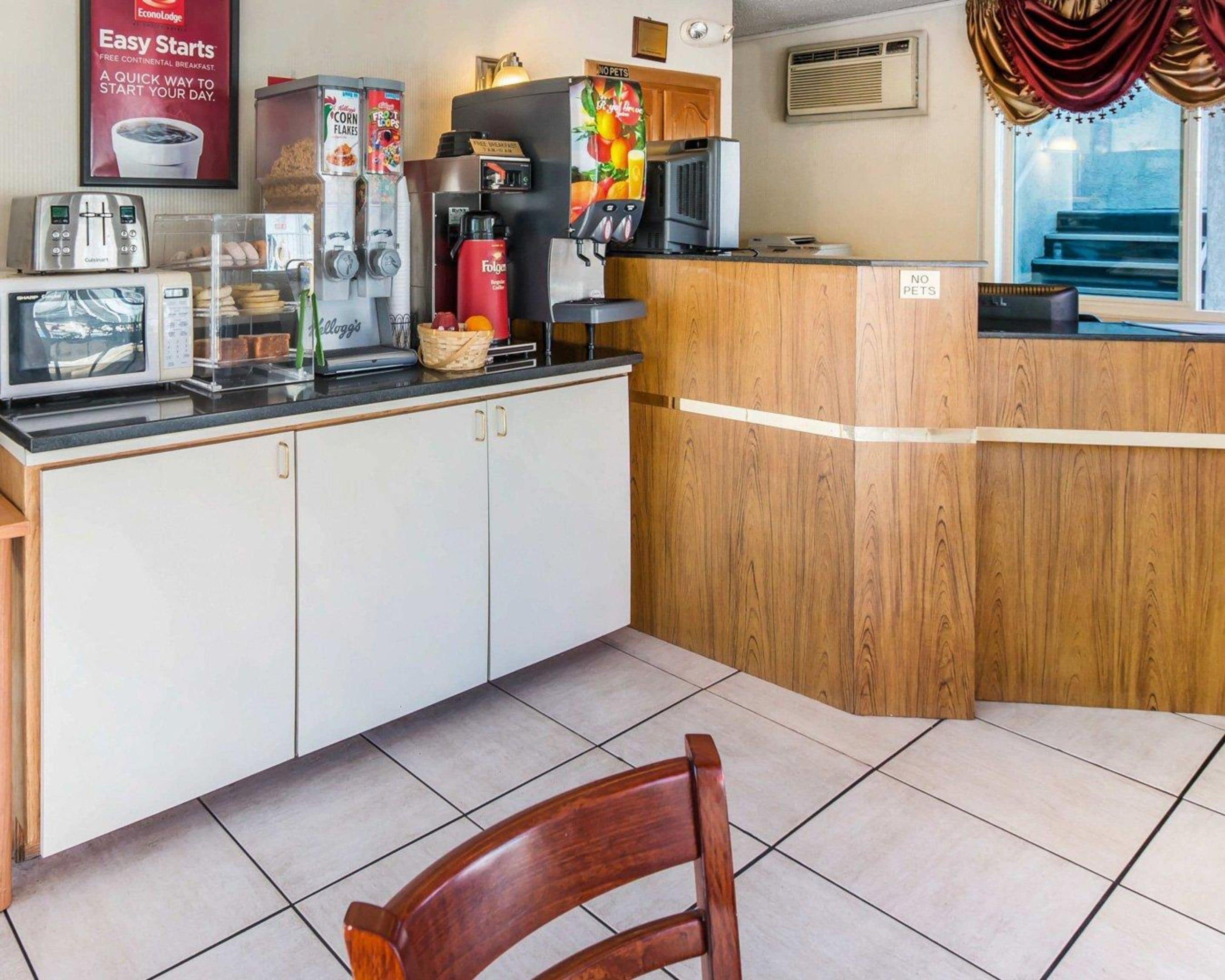 A kitchenette with a microwave, toaster, coffee maker, and cereal dispensers.