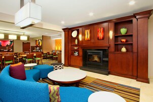 Un hall de hotel con chimenea, zona de estar y bar.