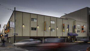 A building with a 'One Way' sign, a 'Soma Park Inn' sign, and multiple flags. - SOMA Park Inn – Civic Center (San Francisco)