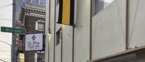 Un edificio con un letrero que dice 'SoMa Park Inn Civic Center' y una señal de calle que indica 'Mission'.