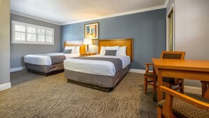 A hotel room with two beds, a wooden table, and a chair. - SOMA Park Inn – Civic Center (San Francisco)