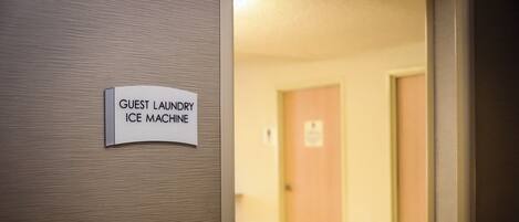 A sign on a wall indicating a guest laundry and ice machine.