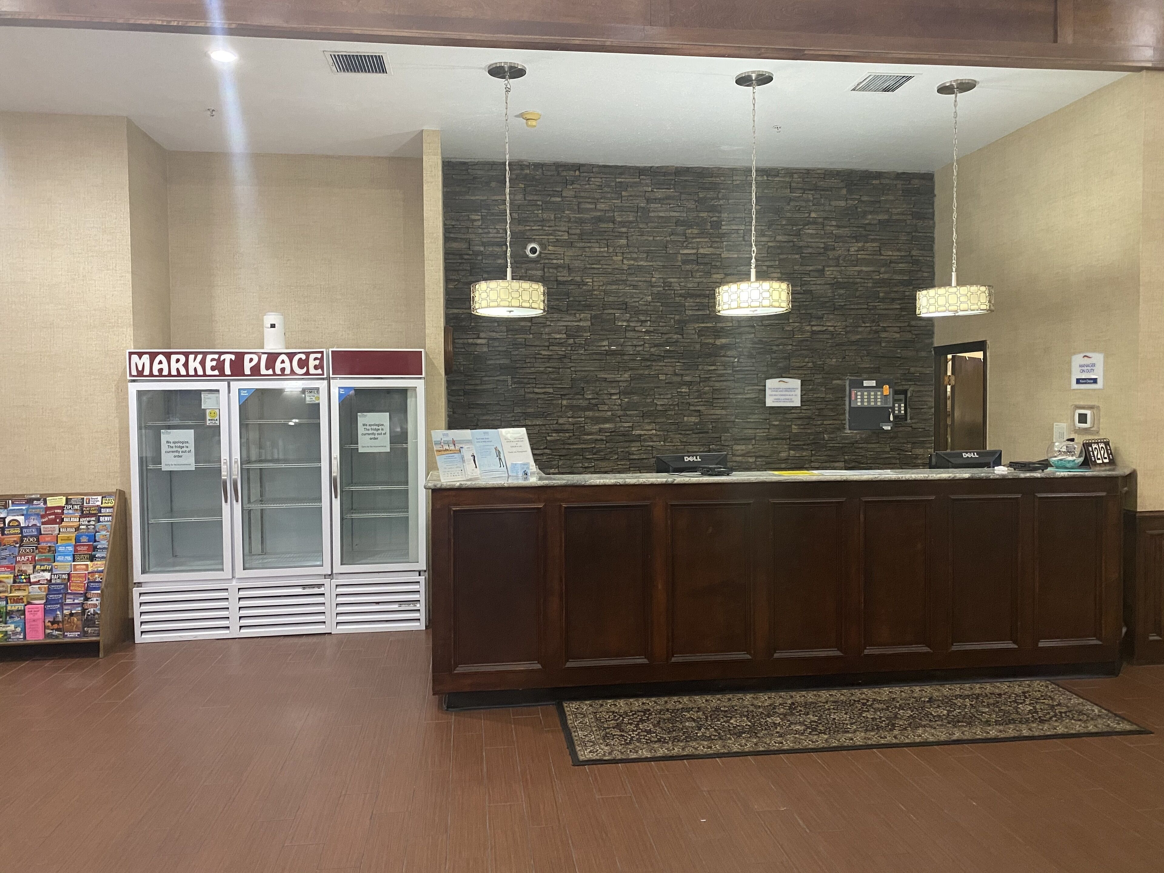 A reception area with a wooden reception desk, a stone wall, and a 'Market Place' sign.