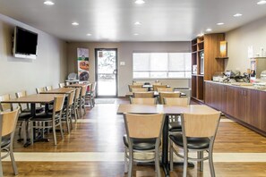 Enjoy meals in a spacious dining area with comfortable seating options and a large window offering a view of the outdoors.