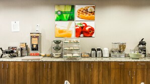 A modern kitchen with a coffee machine, waffle maker, and various food items on the counter.