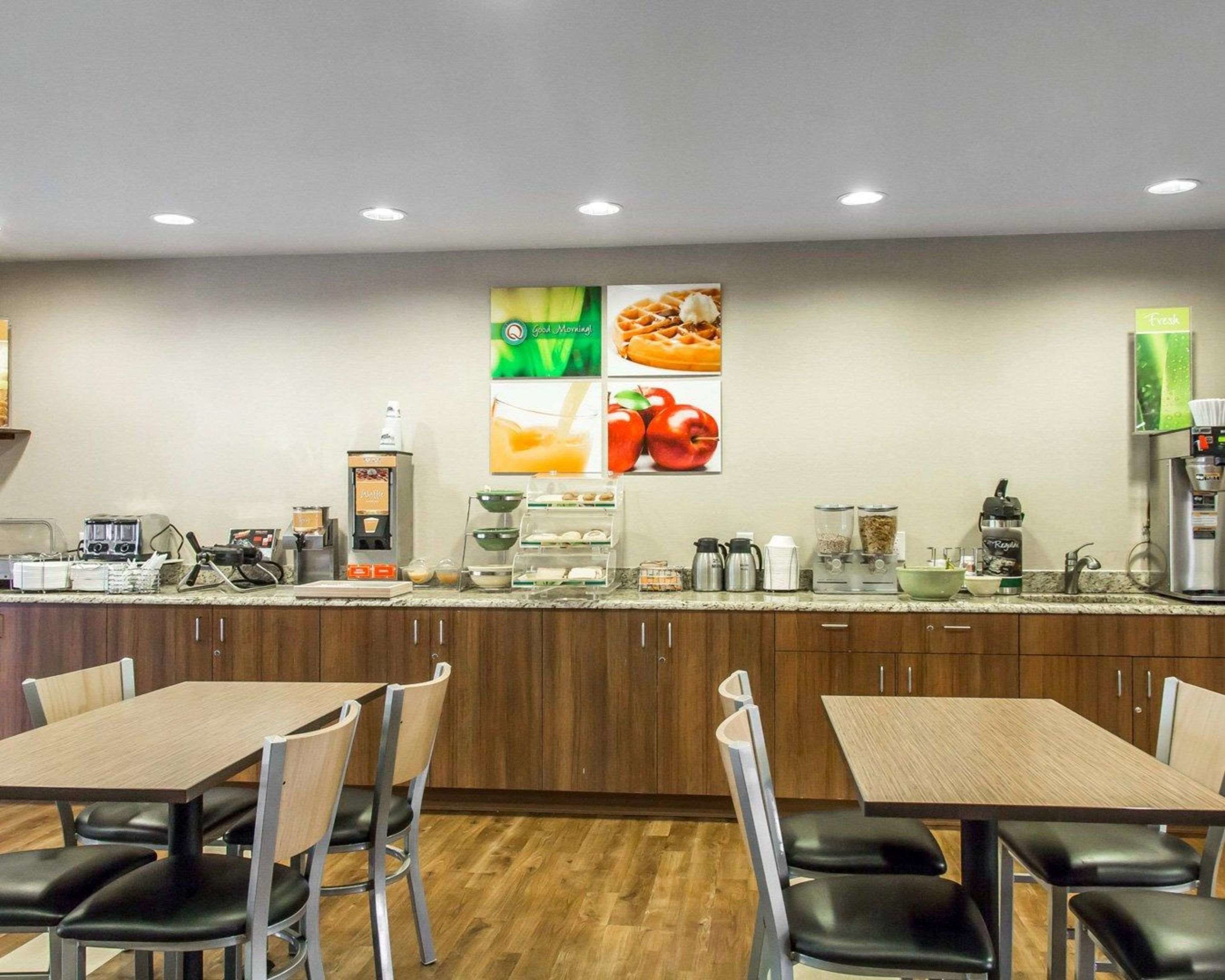 A modern kitchen with wooden cabinets, a coffee machine, and a breakfast bar.