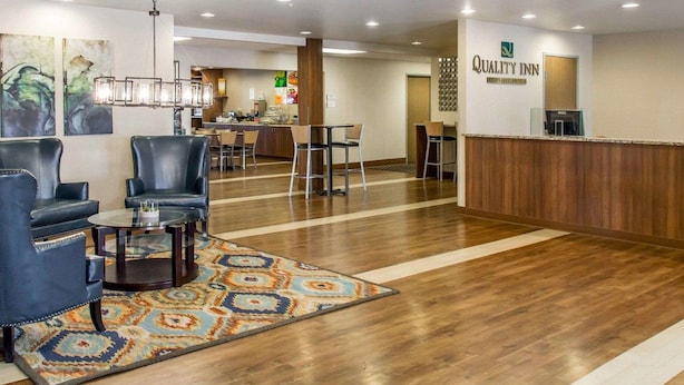 A hotel lobby with a reception desk, seating area, and a dining area.