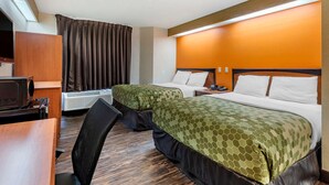 A hotel room with two beds, a desk, a chair, and a TV. - Econo Lodge North Academy (Colorado Springs)
