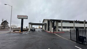A Desert Sands Inn & Suites with a covered parking area and a gated entrance.