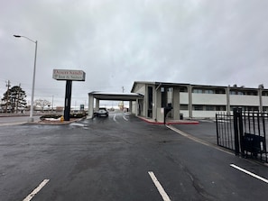 A Desert Sands Inn & Suites with a covered parking area and a gated entrance.