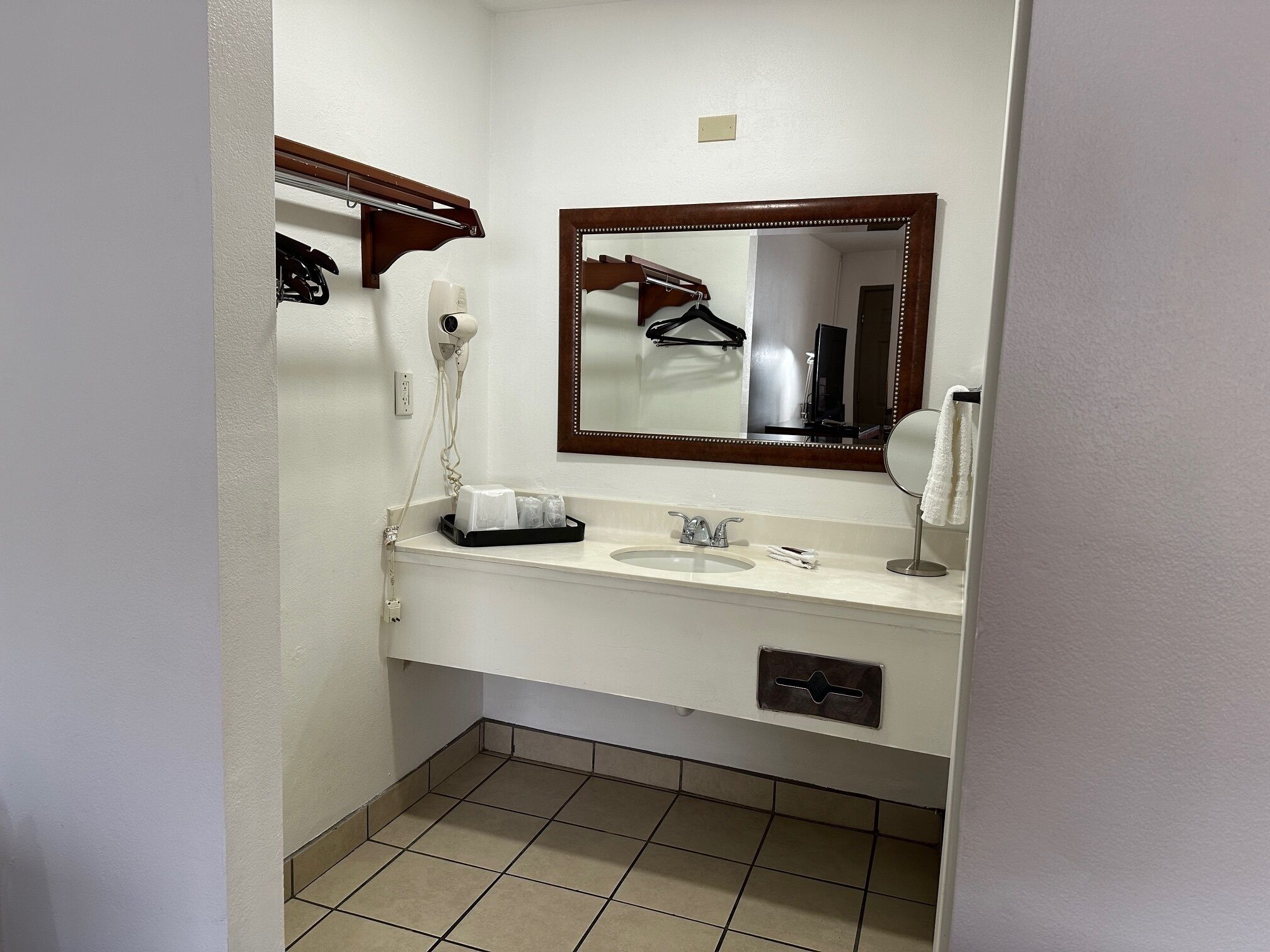 A small bathroom with a sink, mirror, and hairdryer.