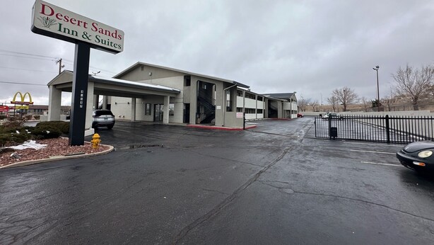 A Desert Sands Inn & Suites with a parking lot and a McDonald's sign in the background.