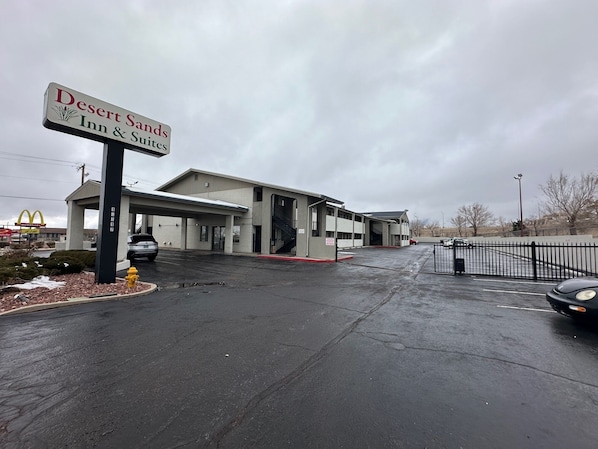 A Desert Sands Inn & Suites with a parking lot and a McDonald's sign in the background.