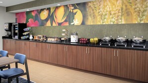A buffet area with a counter, seating, and various food items. - Fairfield Inn & Suites by Marriott Albuquerque Airport (Albuquerque)