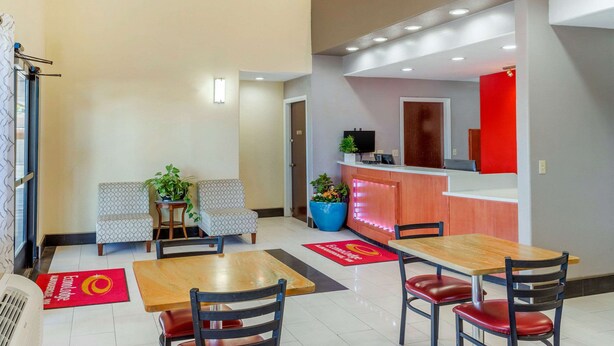 A hotel lobby with a reception desk, seating area, and a dining table. - Econo Lodge West - Coors Blvd (Albuquerque)