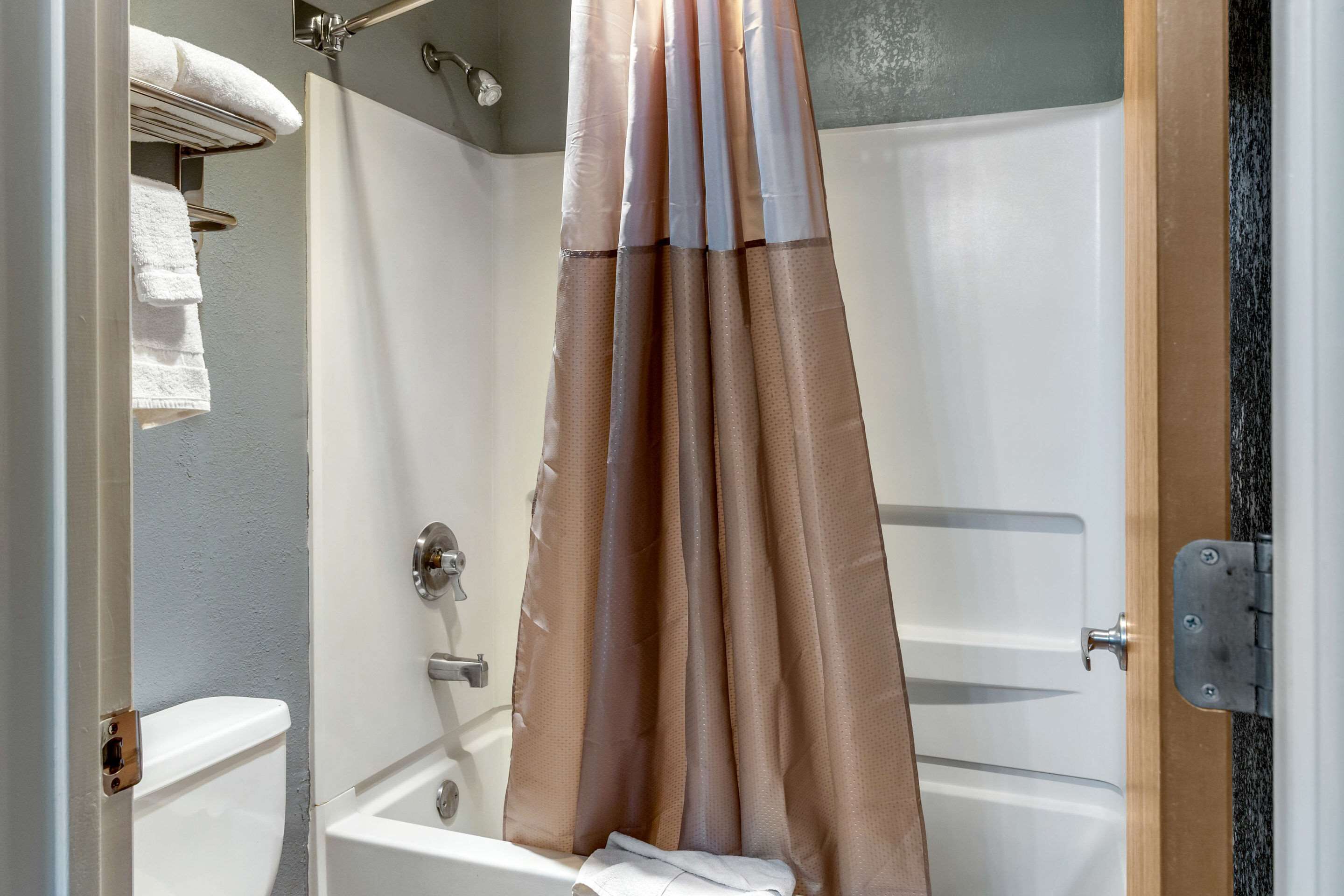 Un baño con bañera, cortina de ducha y retrete.