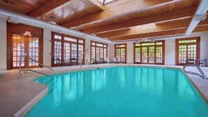 An indoor swimming pool with wooden beams and large windows. - Courtyard by Marriott Albuquerque (Albuquerque)