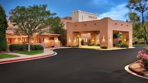 A Courtyard by Marriott hotel with a well-lit entrance, landscaped surroundings, and a clear sky. - Courtyard by Marriott Albuquerque (Albuquerque)