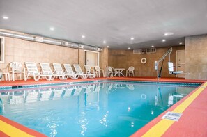 Una piscina techada, sillones reclinables de piscina