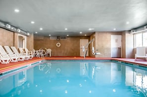 Een binnenzwembad en ligstoelen