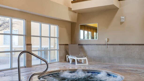 Un espace spa comprenant un bain à remous, un fauteuil et une fenêtre.