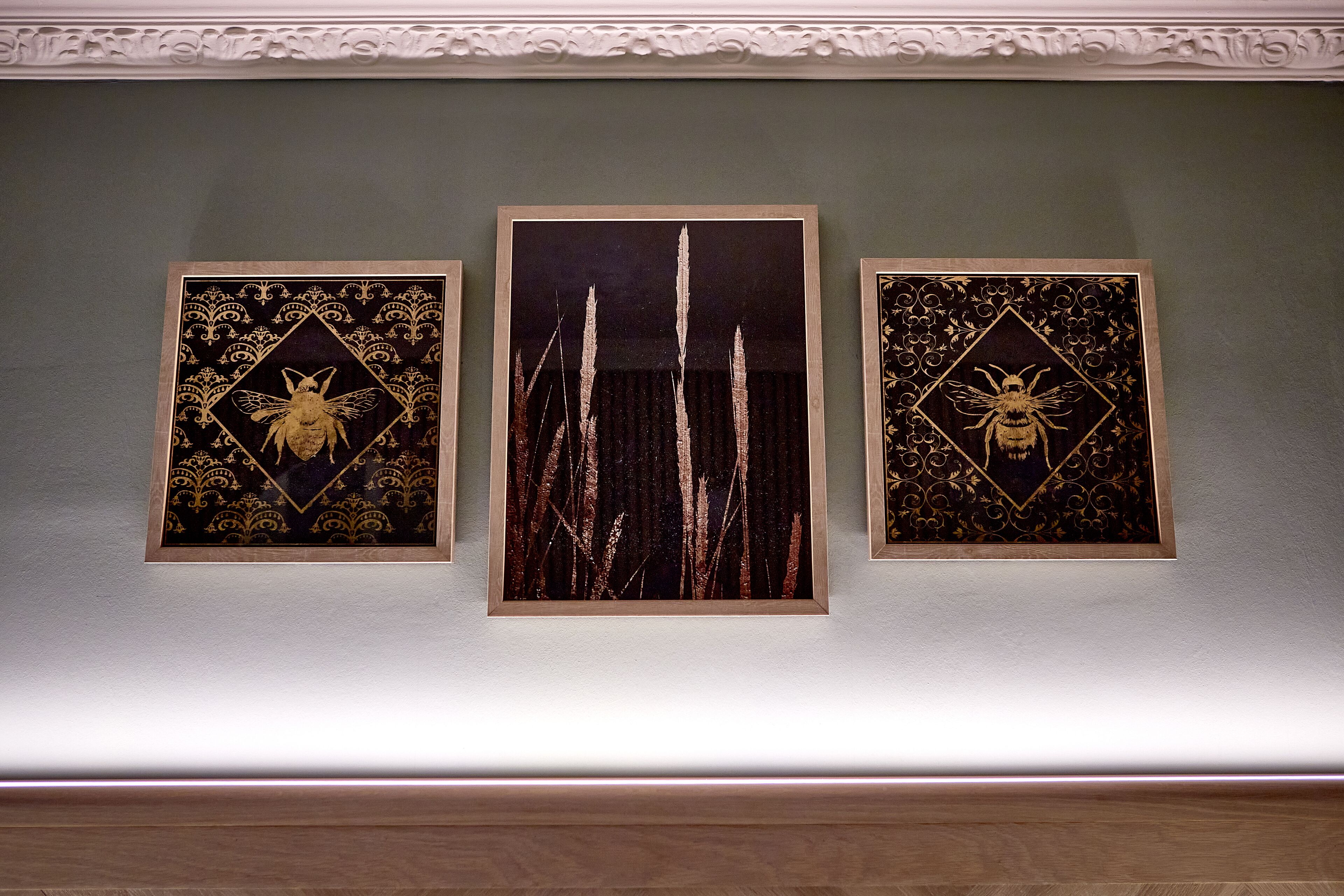 Three framed artworks on a wall.
