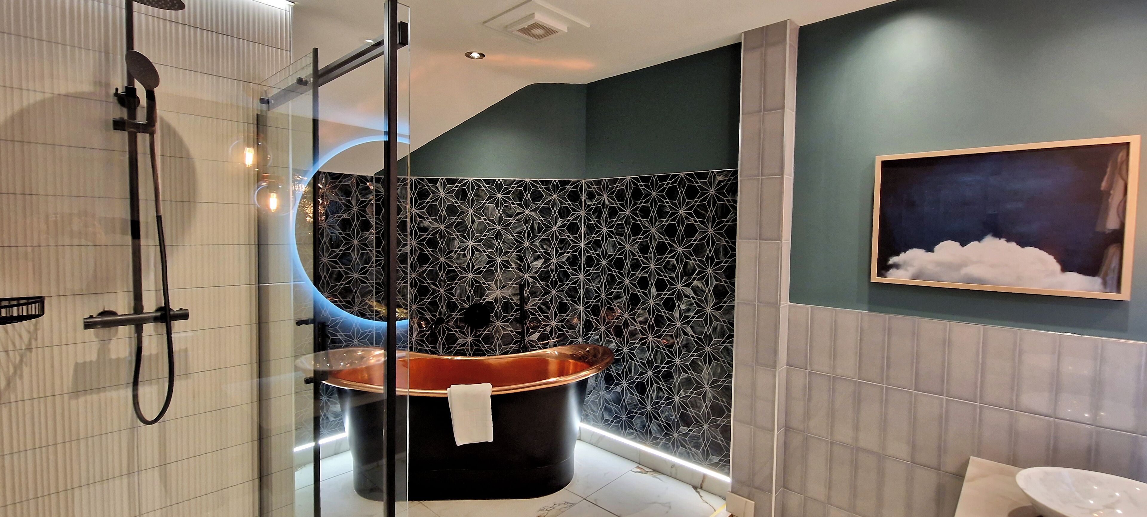 A modern bathroom with a glass-enclosed shower, a freestanding bathtub, and a wall-mounted sink.