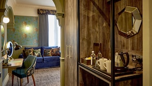 Una habitación con un sofá azul, un escritorio con espejo y un armario con espejo.