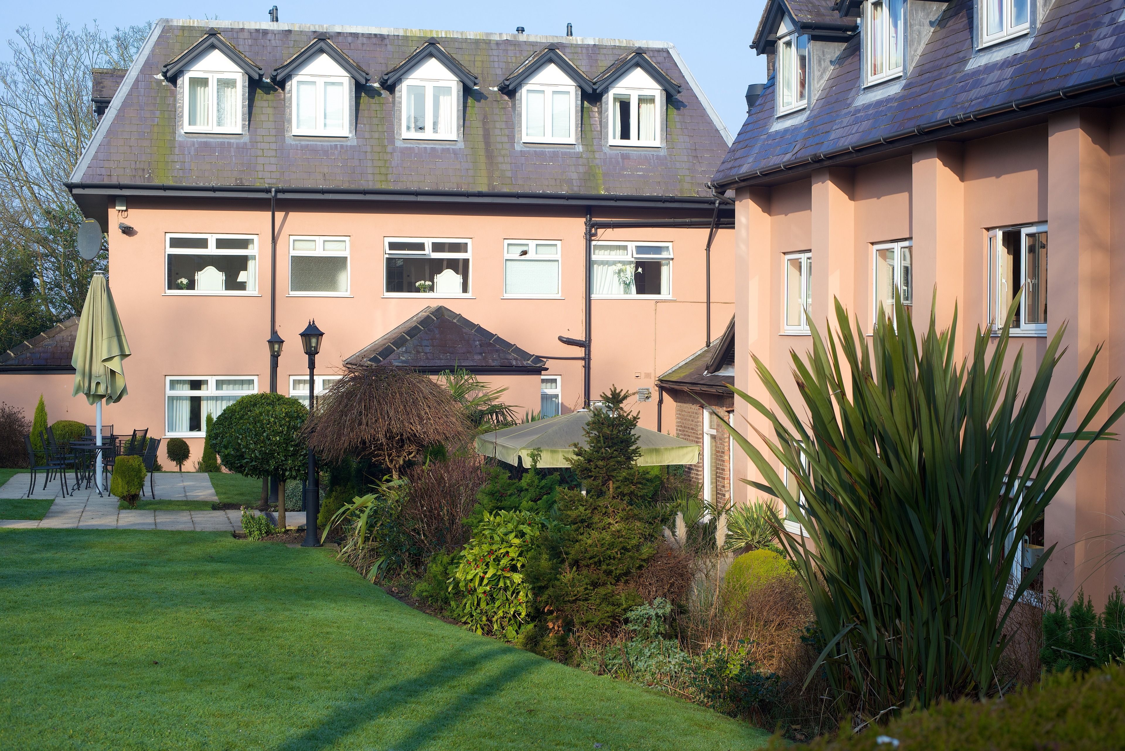 A two-story building with a garden in front.