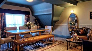 A cozy room with a wooden dining table, leather bench, and a large mirror.