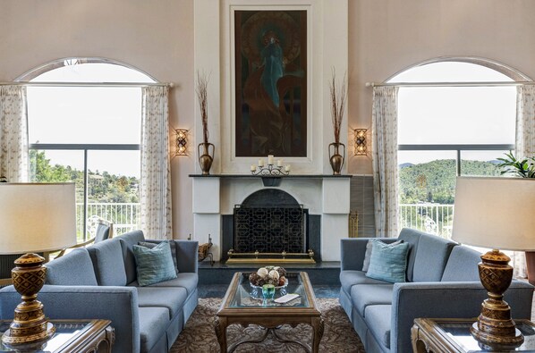 Relax in a classic lounge area with a fireplace, surrounded by a view of the landscape.