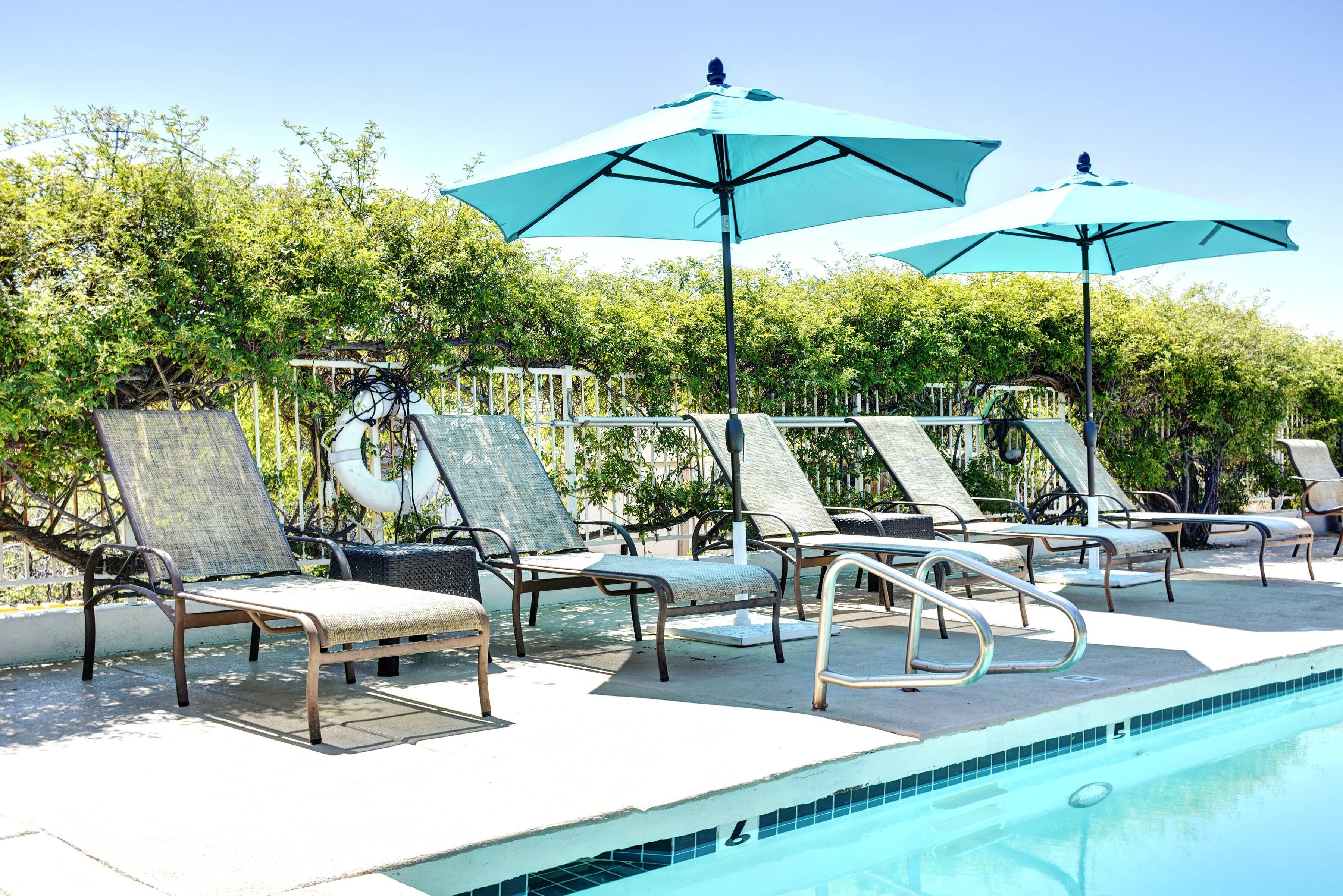 A poolside area with lounge chairs and umbrellas.