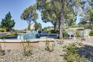 Relax by the serene pool surrounded by lush greenery and a mosaic tile border.