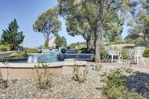 Relax by the serene pool surrounded by lush greenery and a mosaic tile border.