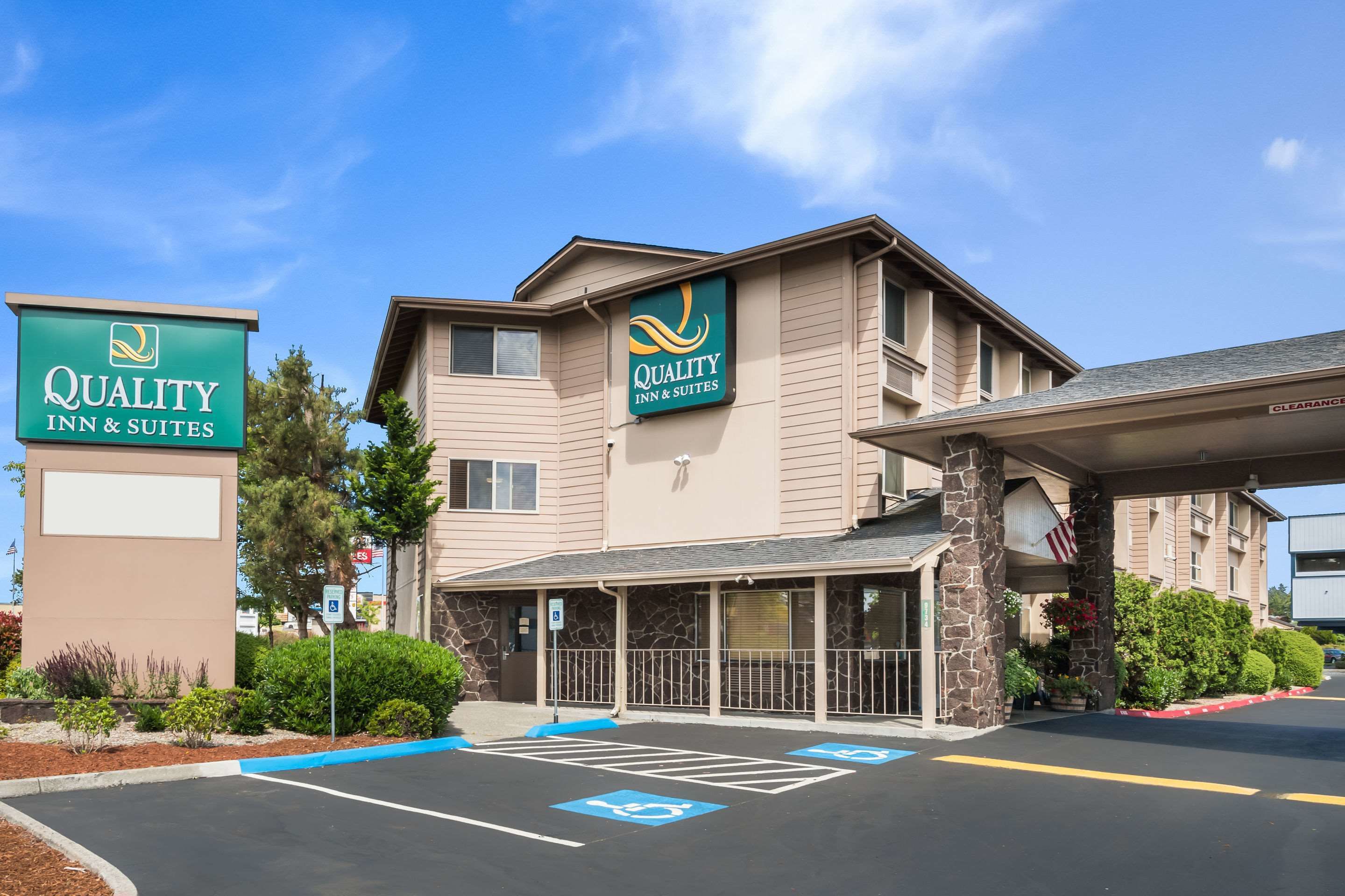 Um hotel com uma placa indicando "Quality Inn & Suites" e uma entrada coberta.