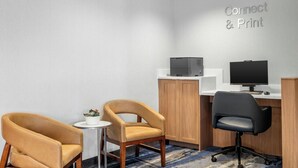 A modern office space with two chairs, a desk, a computer, and a printer.