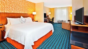 A hotel room with a large bed, a desk, a chair, a television, and a patterned carpet. - Fairfield Inn & Suites by Marriott Madison West/Middleton (Middleton)
