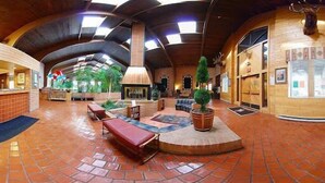 A spacious lobby with a high ceiling, a reception desk, seating areas, and a central decorative element. - Douglas Inn & Conference Center (Douglas)