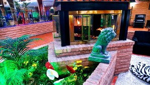 A stone lion statue in a landscaped garden area with a fire feature in the background. - Douglas Inn & Conference Center (Douglas)
