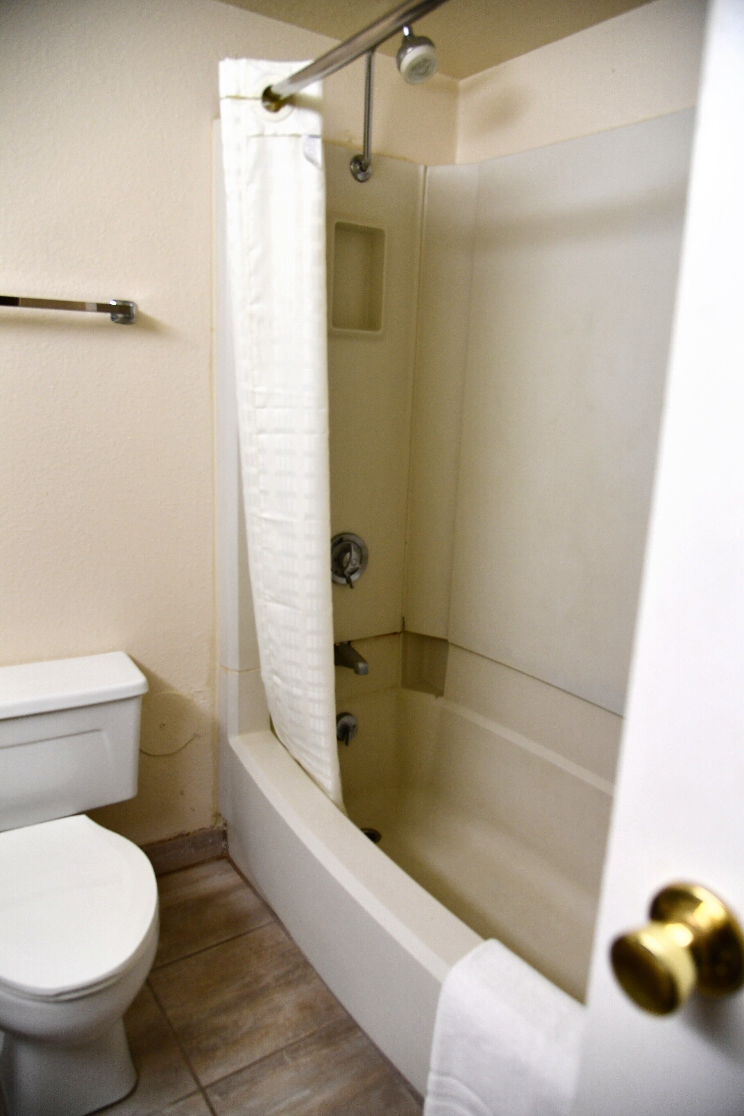 A bathroom with a toilet, a shower with a glass door, and a bathtub.