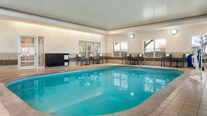 A swimming pool with tiled flooring, a flat ceiling, and a television on a stand.
