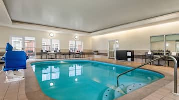 Una piscina techada, sillones reclinables de piscina