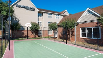 A tennis court adjacent to a building with a sign reading "Residence Inn."