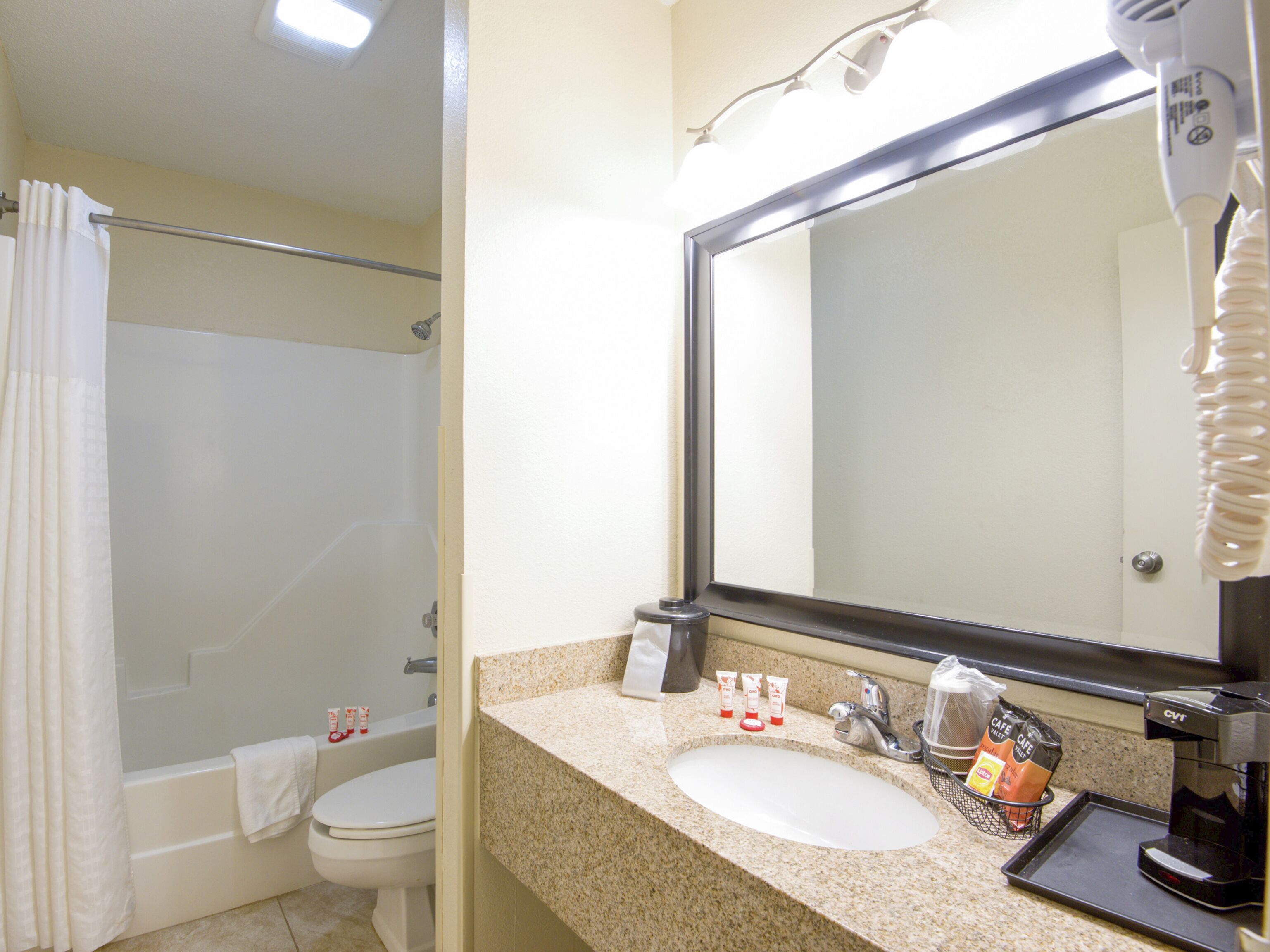 A bathroom with a sink, mirror, and toiletries.