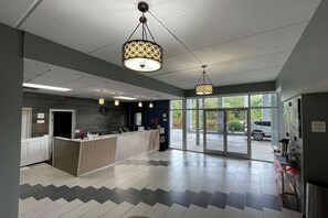 Welcome to our reception area, featuring a contemporary reception desk and a large window offering a view of the outdoors.